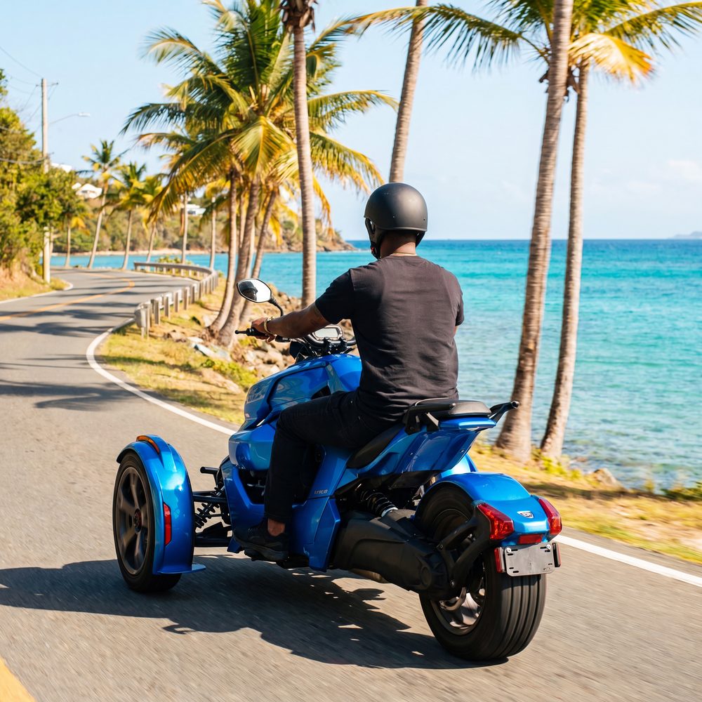 Rider cruising a scenic St. Thomas coastal road on a three-wheel trike