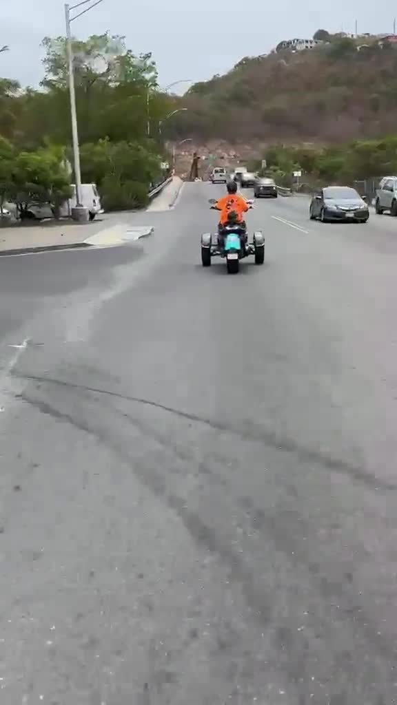 Rider in an orange Trikes & Tings VI shirt cruising a St. Thomas road on a three-wheel Super Trike