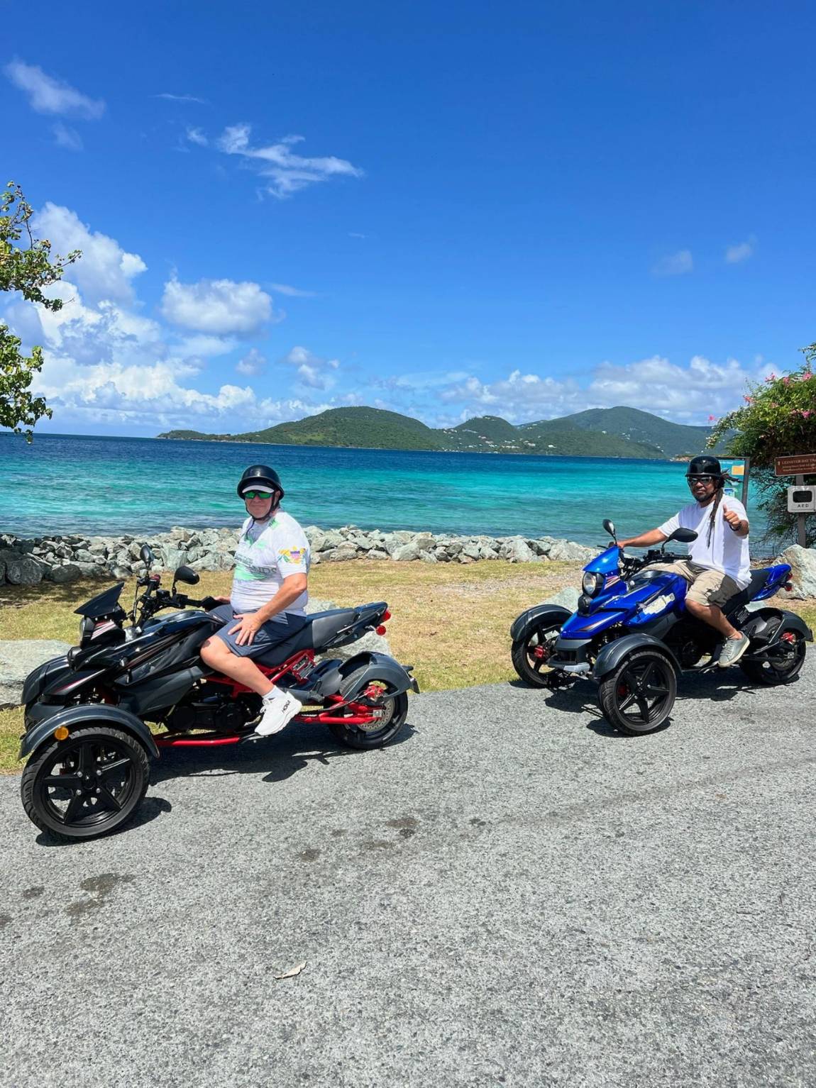 Two riders on trikes at a scenic ocean overlook near Annaberg on St. John