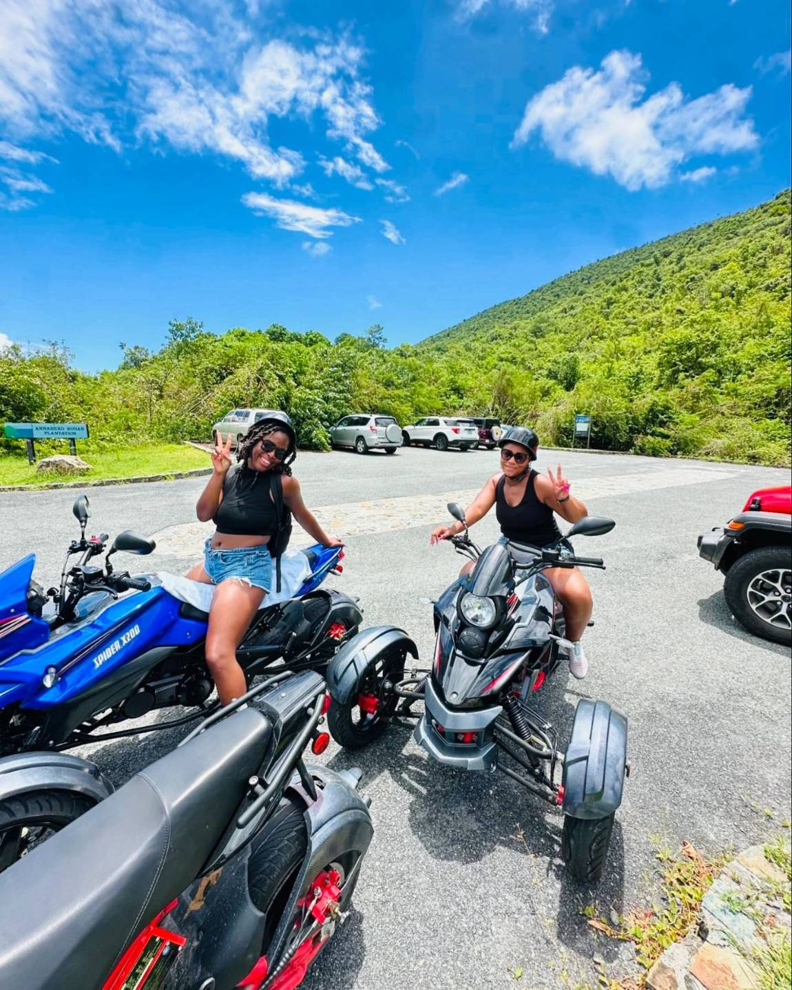 Two riders on trikes at a mountain lookout on St. John