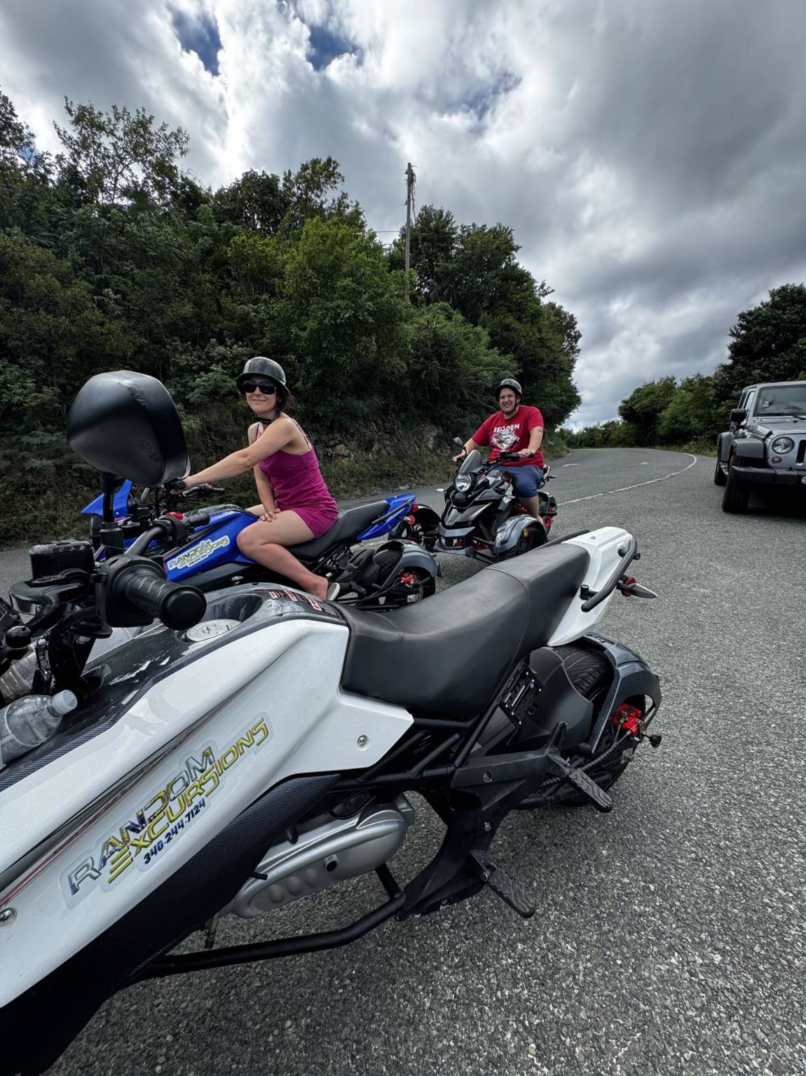 A smiling rider on a three-wheel trike on a St. John road