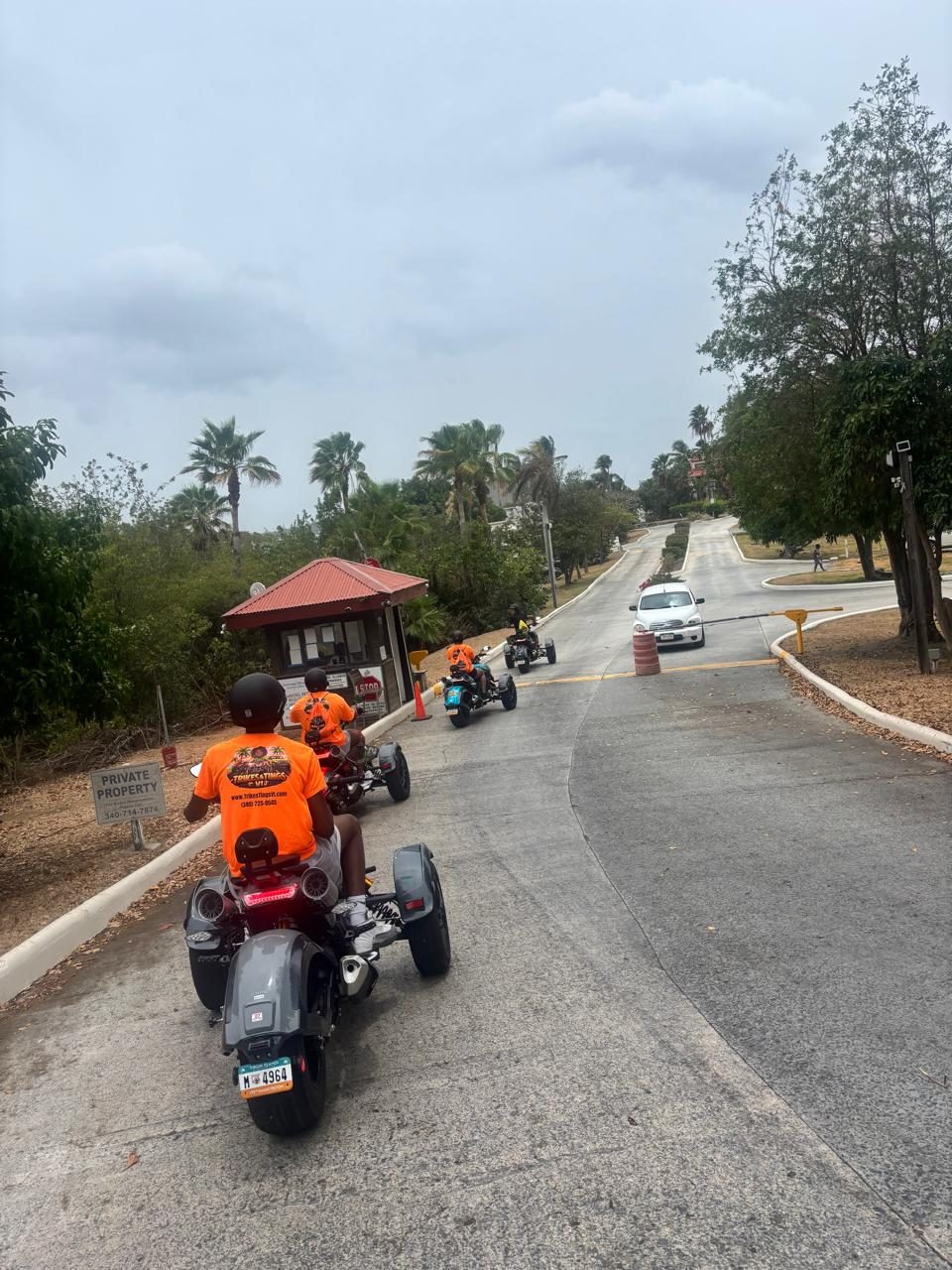 A guided group heads down an island road on three-wheel Super Trikes