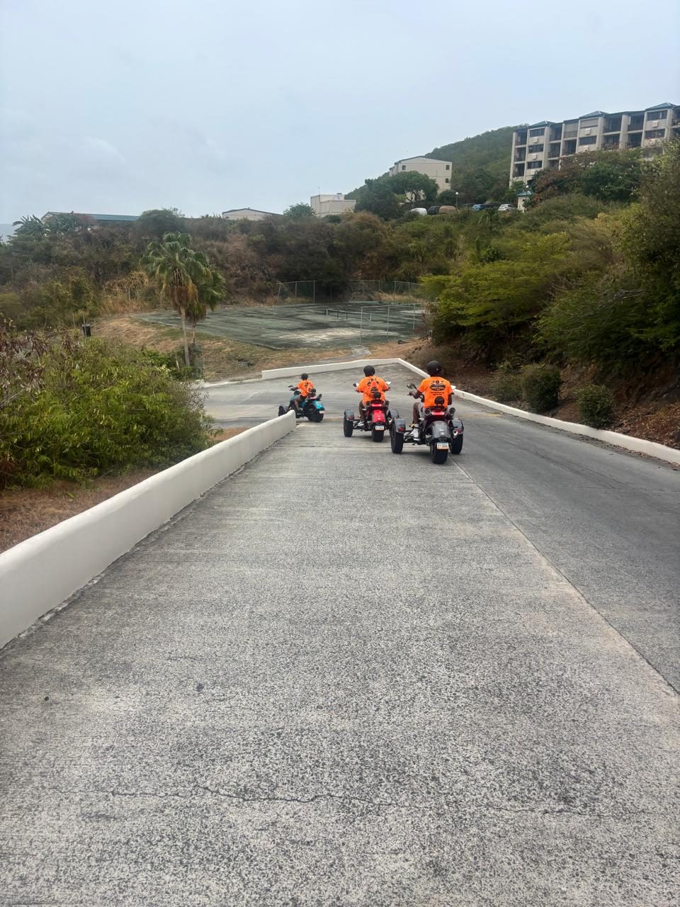Riders climbing a scenic paved hill during the guided tour